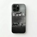 Man holding a phone with 'SABR' branding on a city street